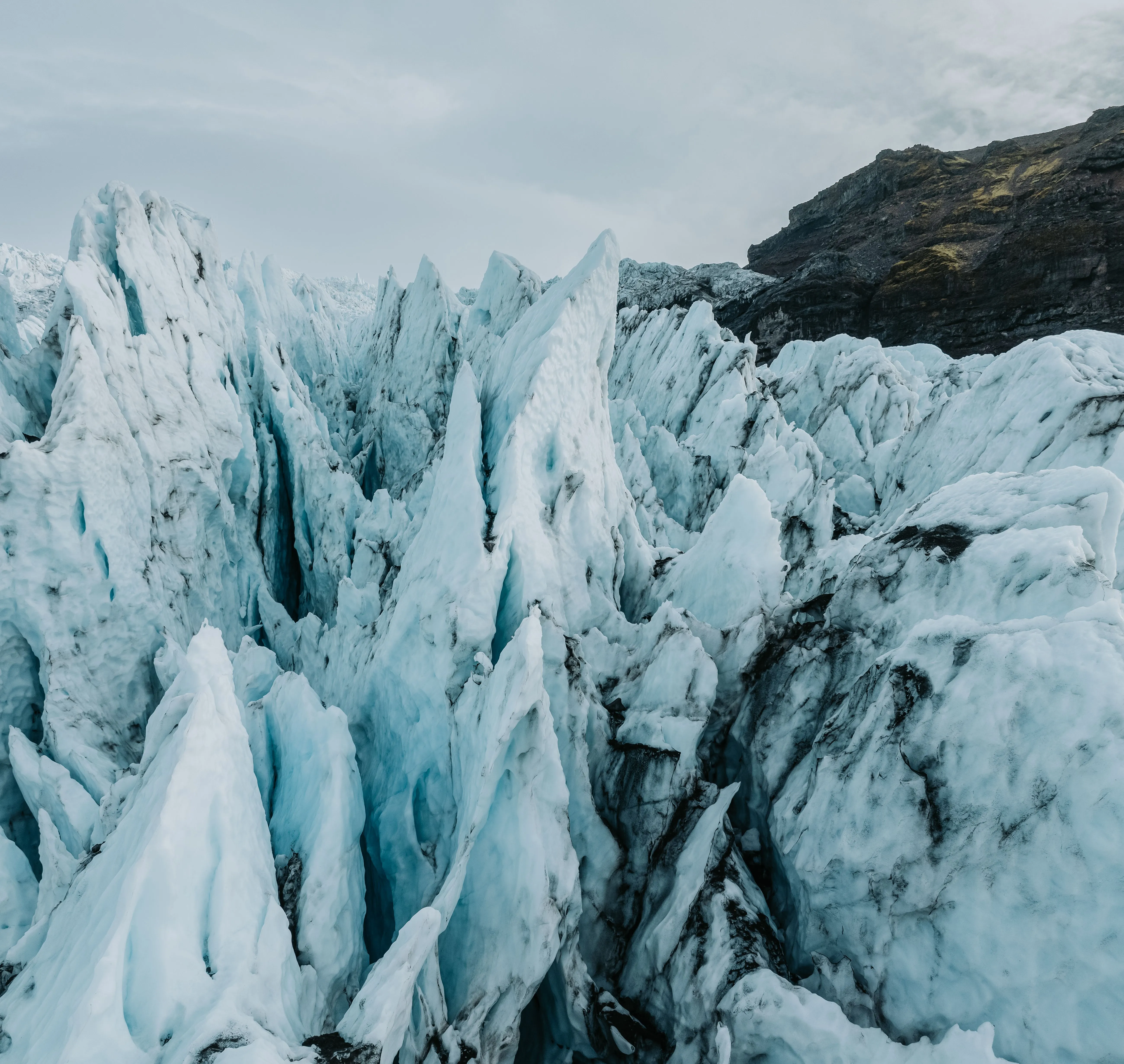 Sharp, blue tinted glacial formations on Falljökull glacier look like massive spikes of ice.