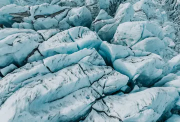A section of chaotic glacier ice on Falljökull, with a network of cracks and deep blue crevasses.