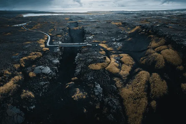 A small bridge crossing over the fissure where the Eurasian and North American tectonic plates divide on the Reykjanes Peninsula.