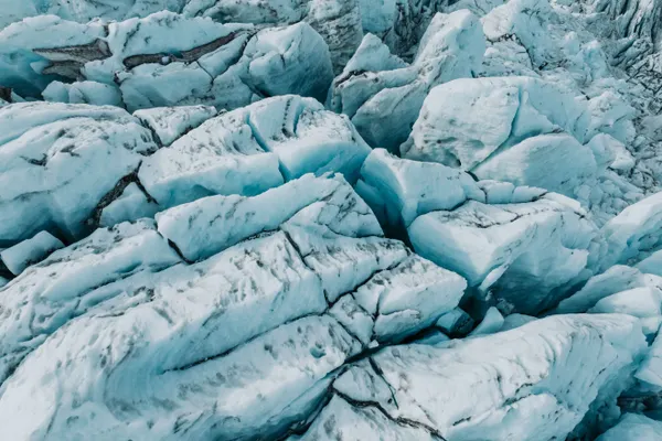 A section of chaotic glacier ice on Falljökull, with a network of cracks and deep blue crevasses.